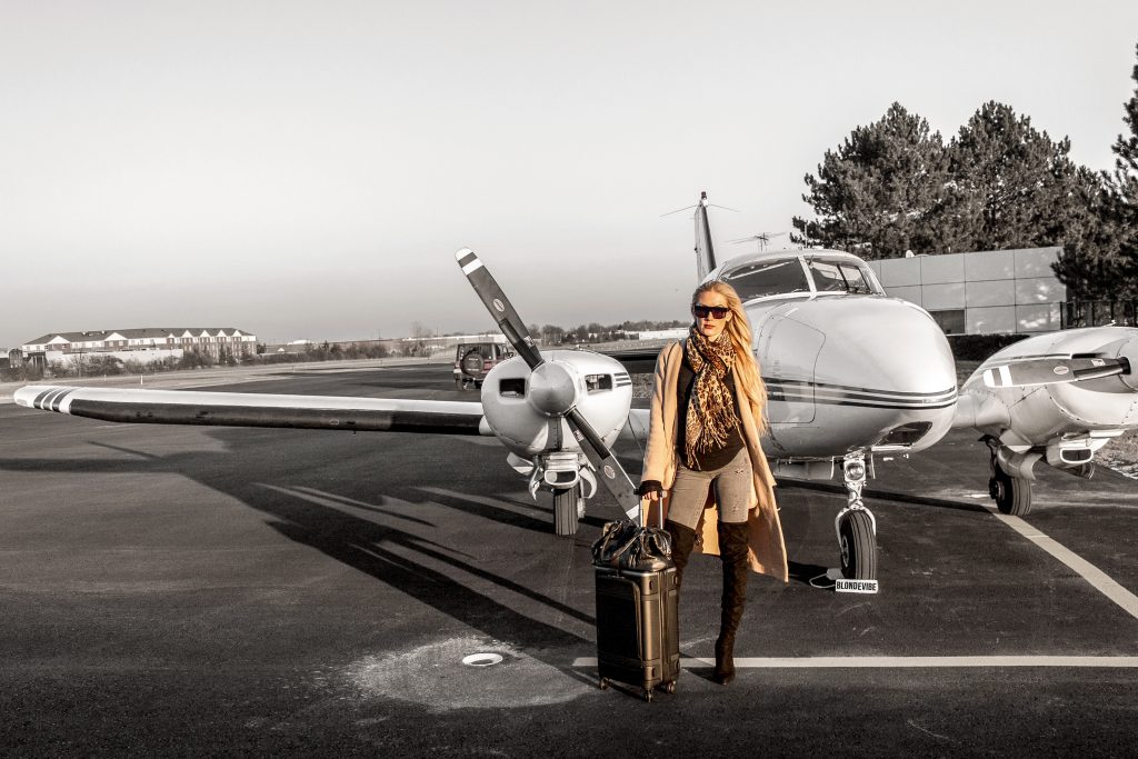 Blonde Vibe standing in front of private jet at airport